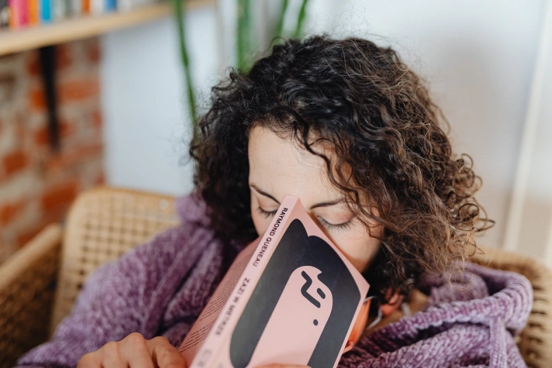curly haired woman reading a book