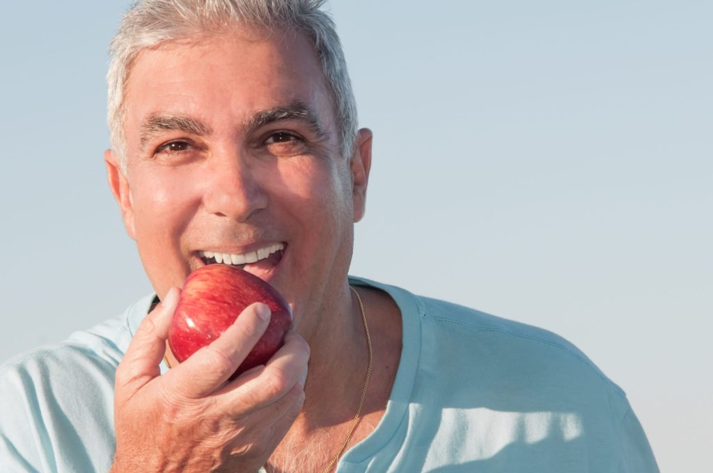 senior man eating apple